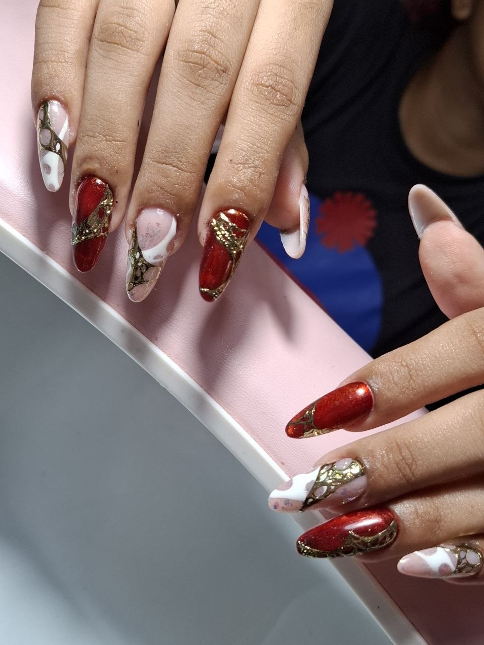 Uñas rojas con diseño dorado